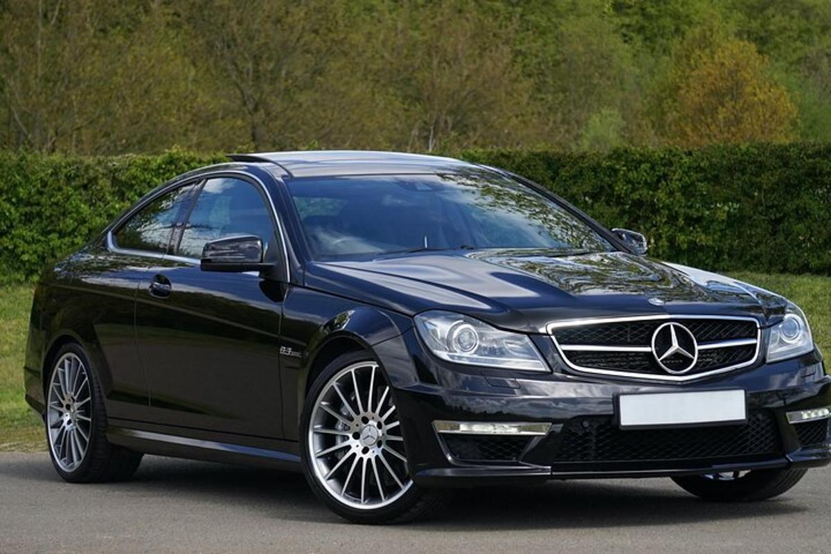 a black mercedes benz car parked on a road
