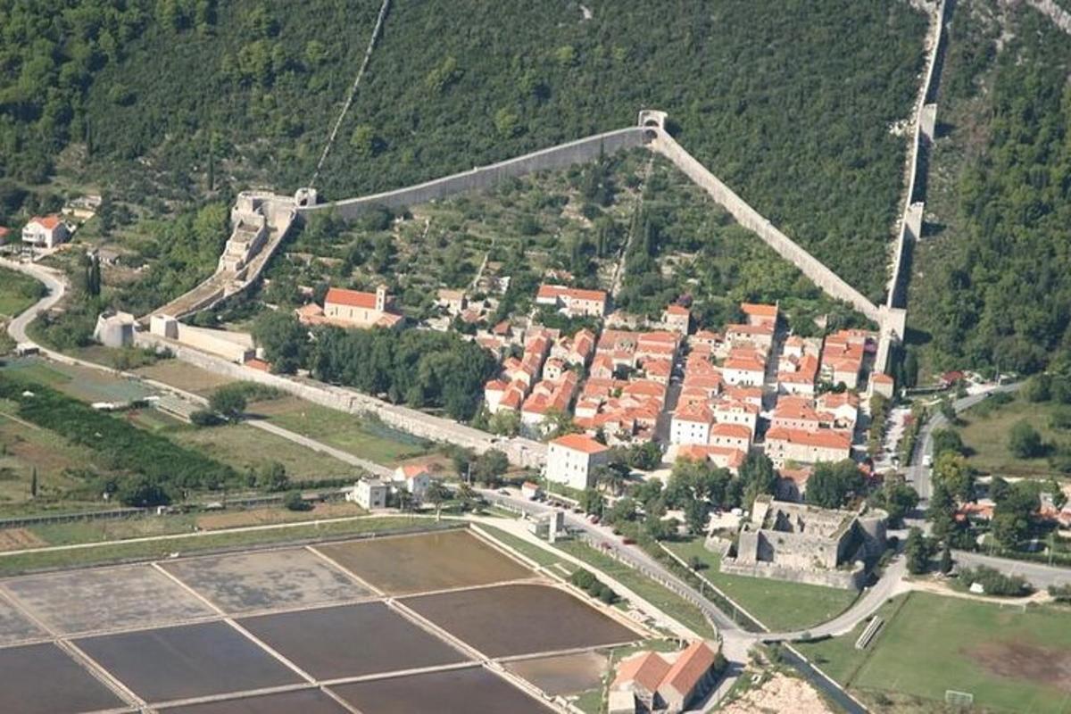 uma vista aérea de uma quadra de tênis e uma cidade