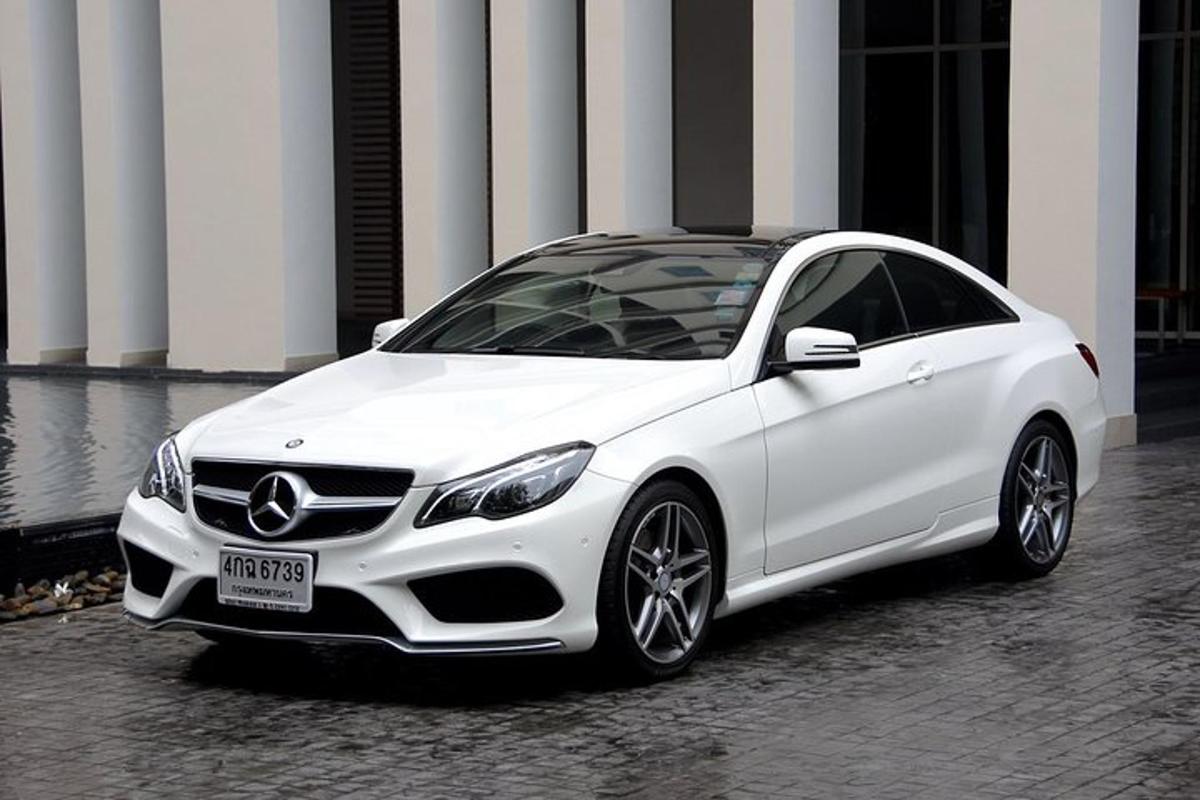 um carro branco estacionado em frente a um prédio