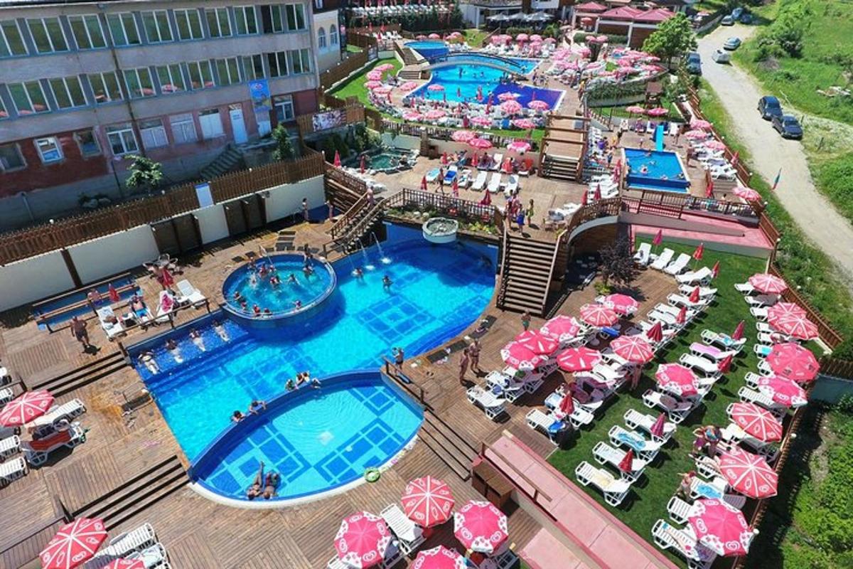 an aerial view of a resort with two pools and umbrellas