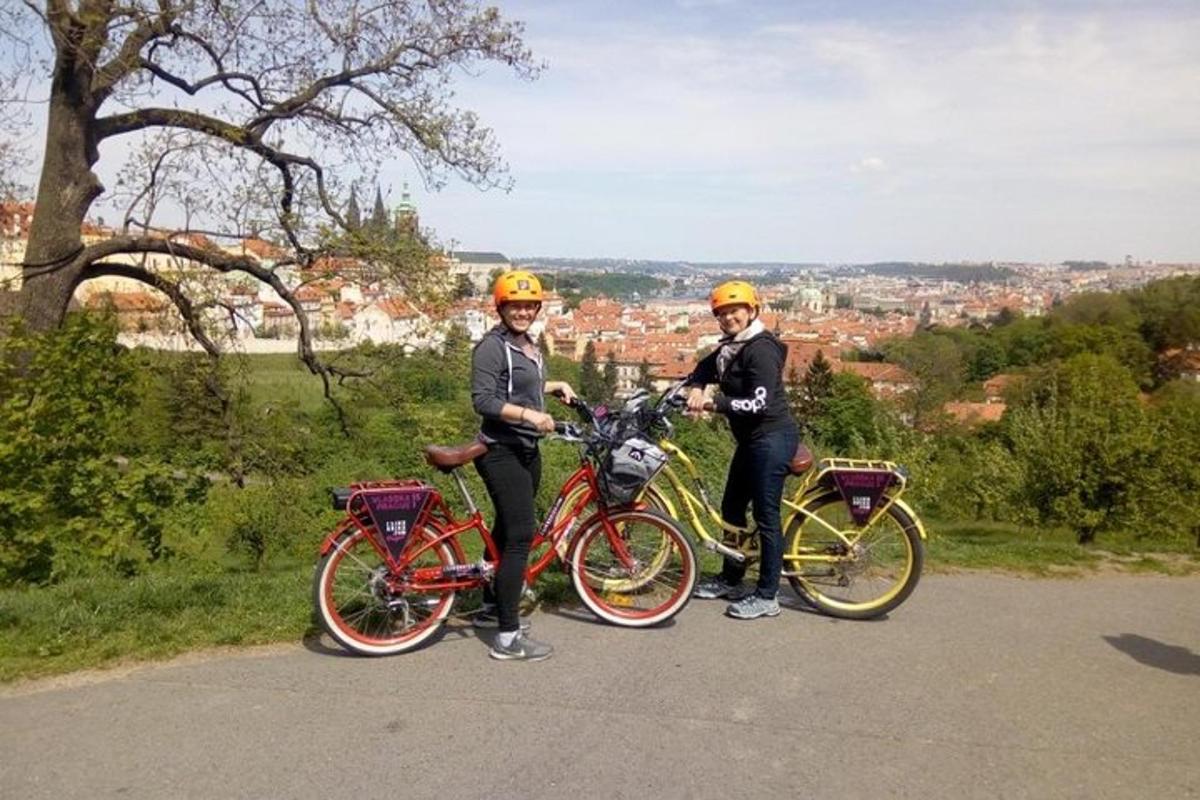 twee mensen staan met hun fietsen op een heuvel