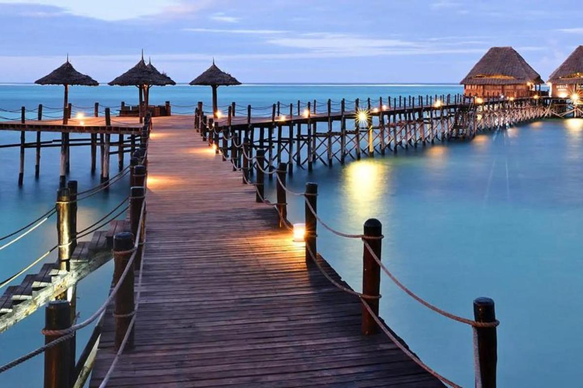 a pier with umbrellas on the water at night