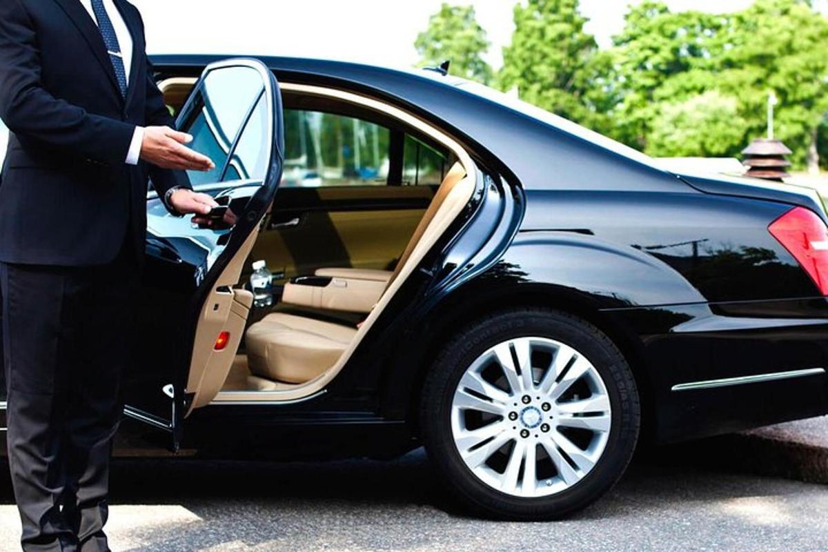 Un hombre con traje subiéndose a un coche.