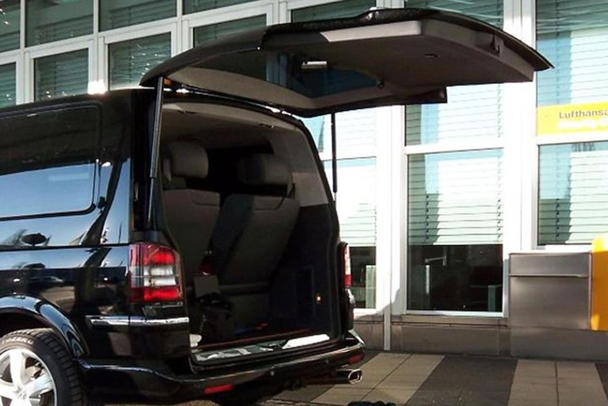 Una camioneta negra con la puerta abierta estacionada en un estacionamiento