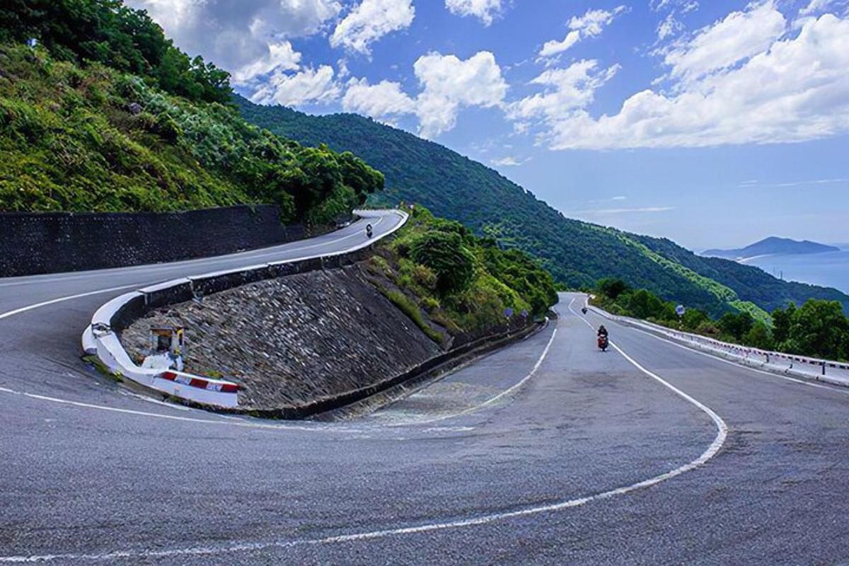 một con đường quanh co trên đồi với một người đang đi xe máy