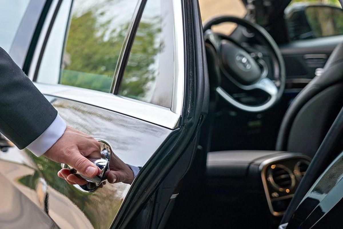 Un hombre sostiene la puerta de un coche.