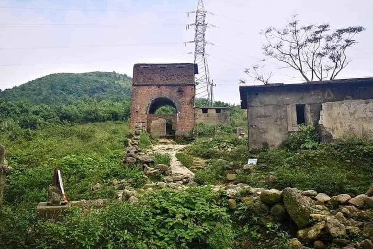 Un edificio antiguo en un campo con un túnel.