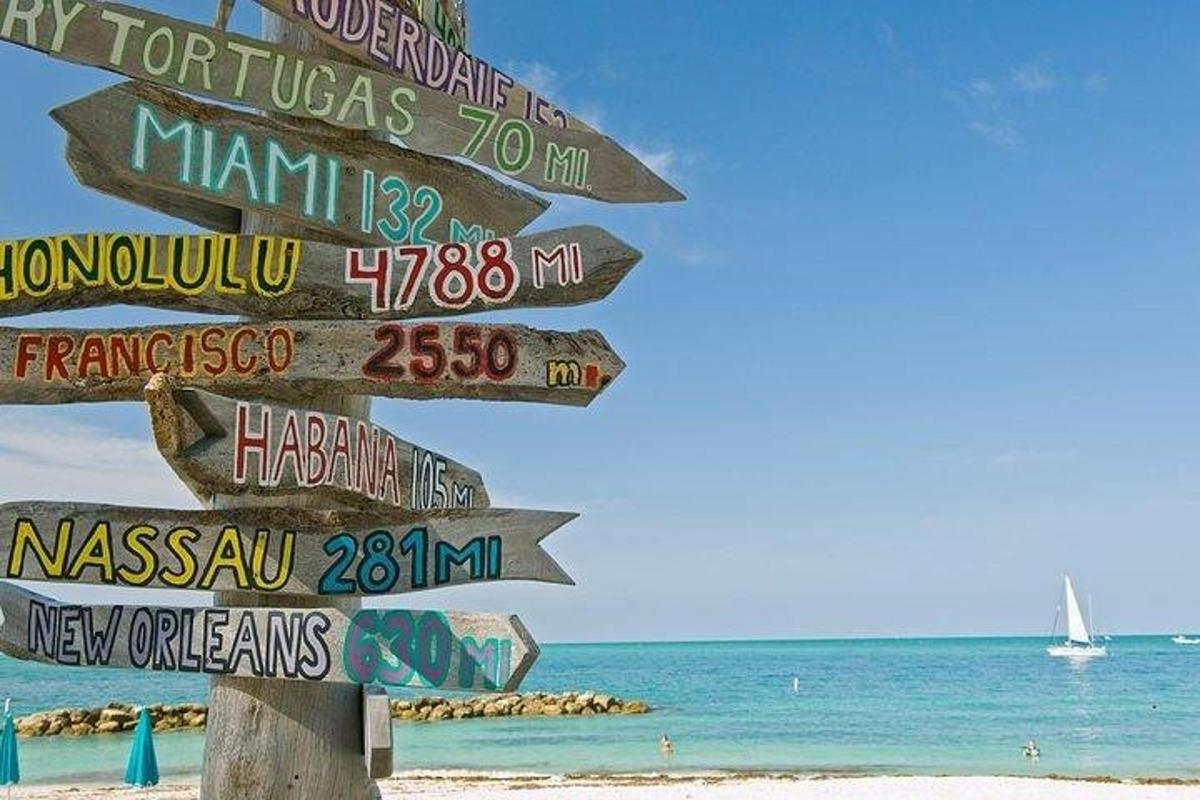 a street sign on a beach with the ocean