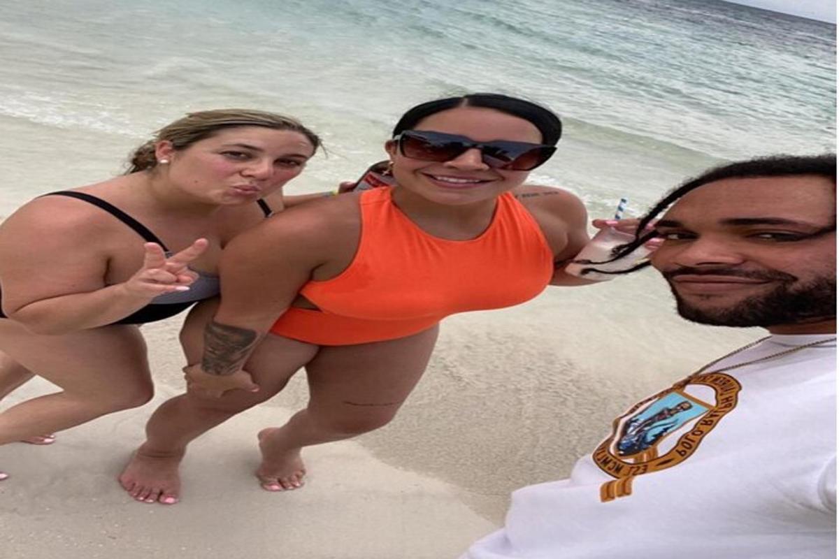 due donne e un uomo in piedi sulla spiaggia