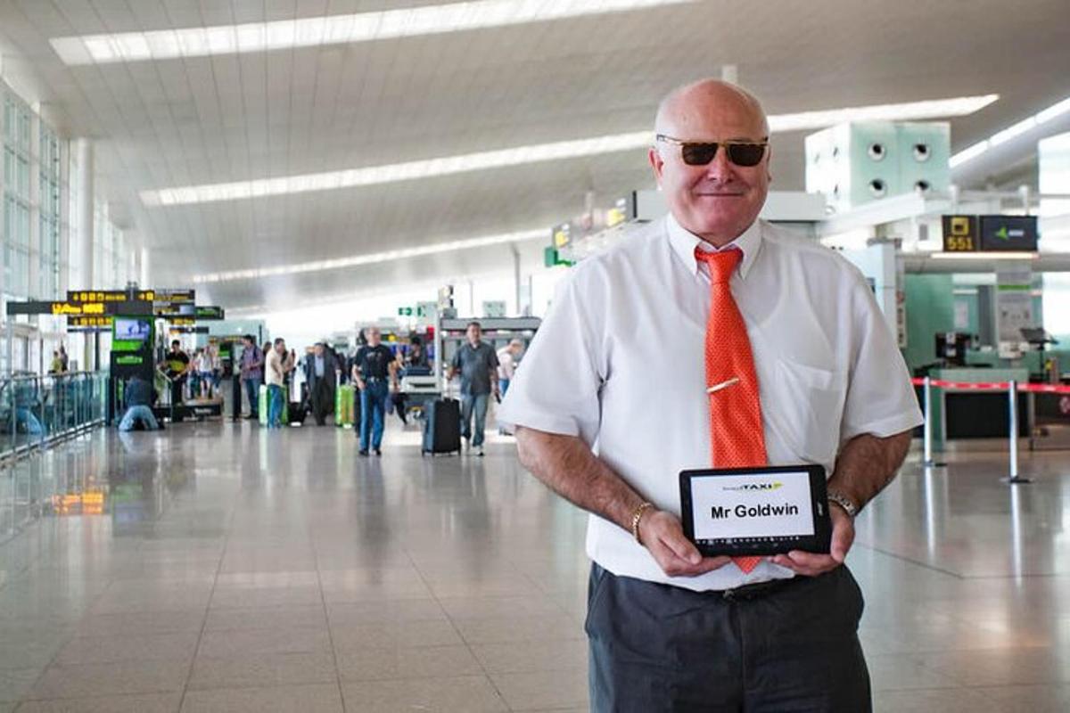 un uomo che indossa una cravatta rossa e tiene un cartello in un aeroporto