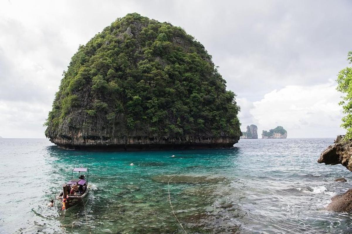 una barca in acqua di fronte a una piccola isola