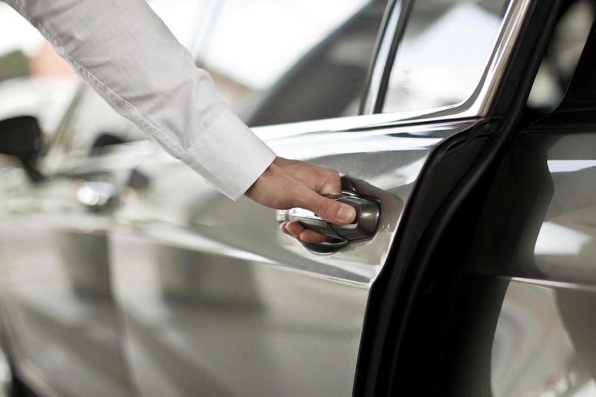 a man opening a car door with his hand