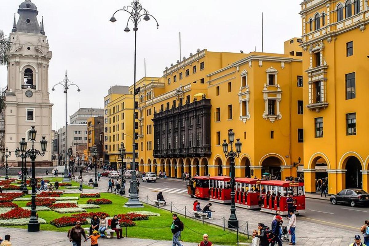 una ciutat amb edificis grocs i un carrer amb autobusos