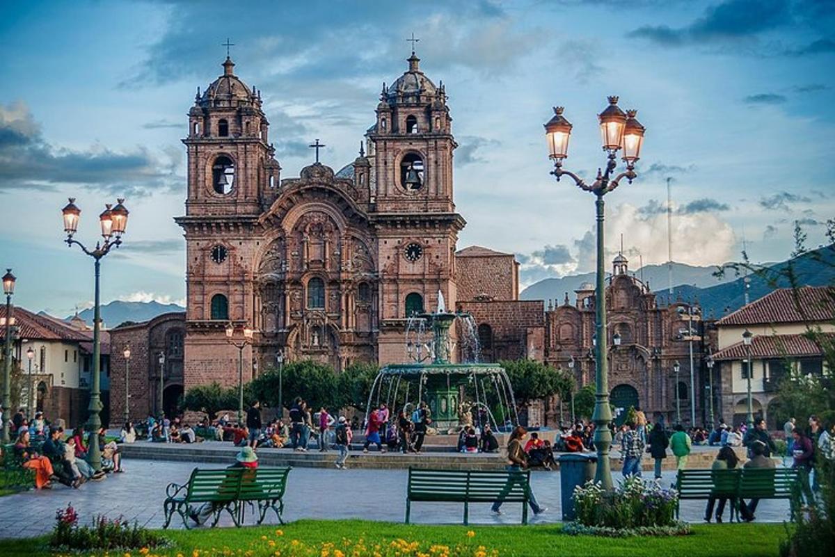 Un gran edificio con gente sentada frente a él.