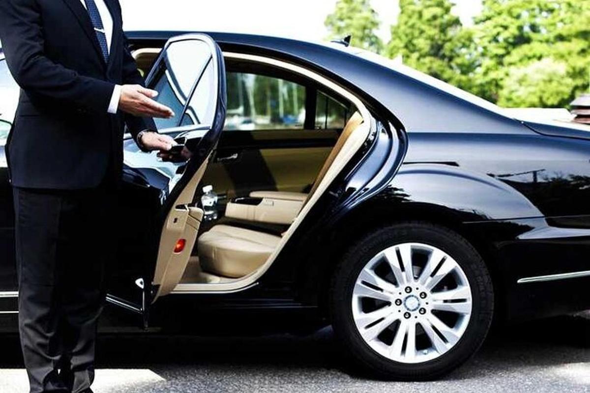 một người đàn ông mặc vest đang bước vào xe