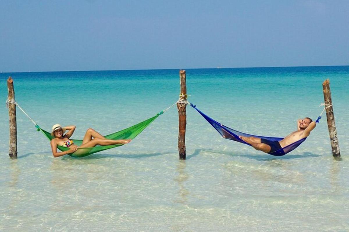 dues persones estirades en hamaques a la platja