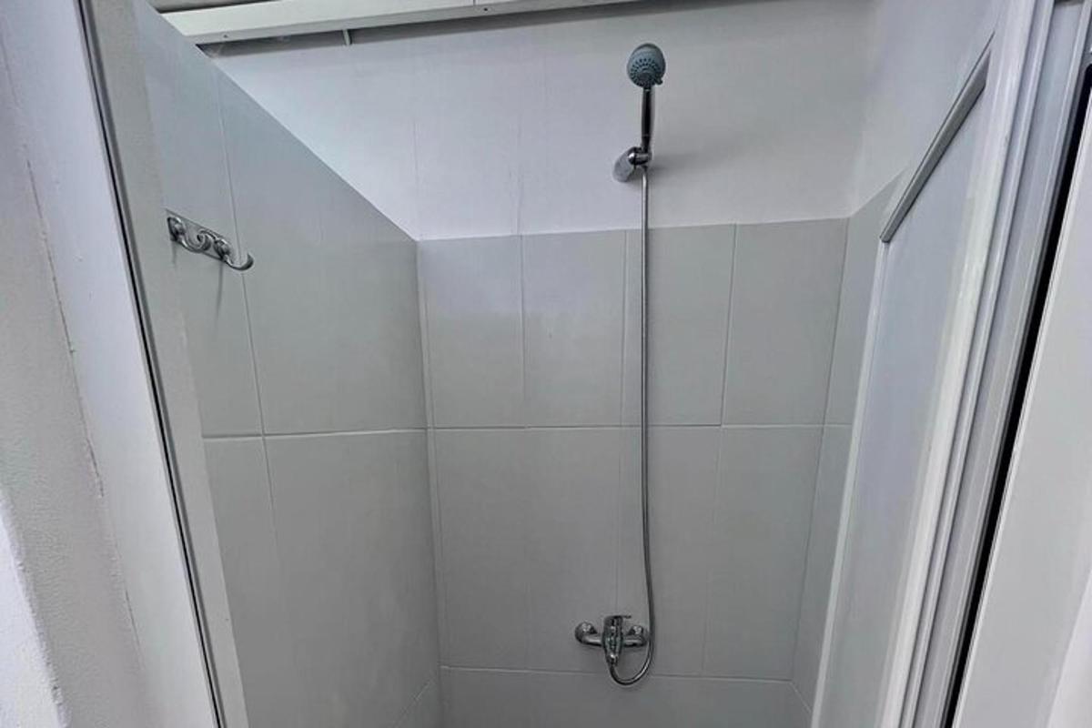 un duș cu ușă de sticlă într-o baie