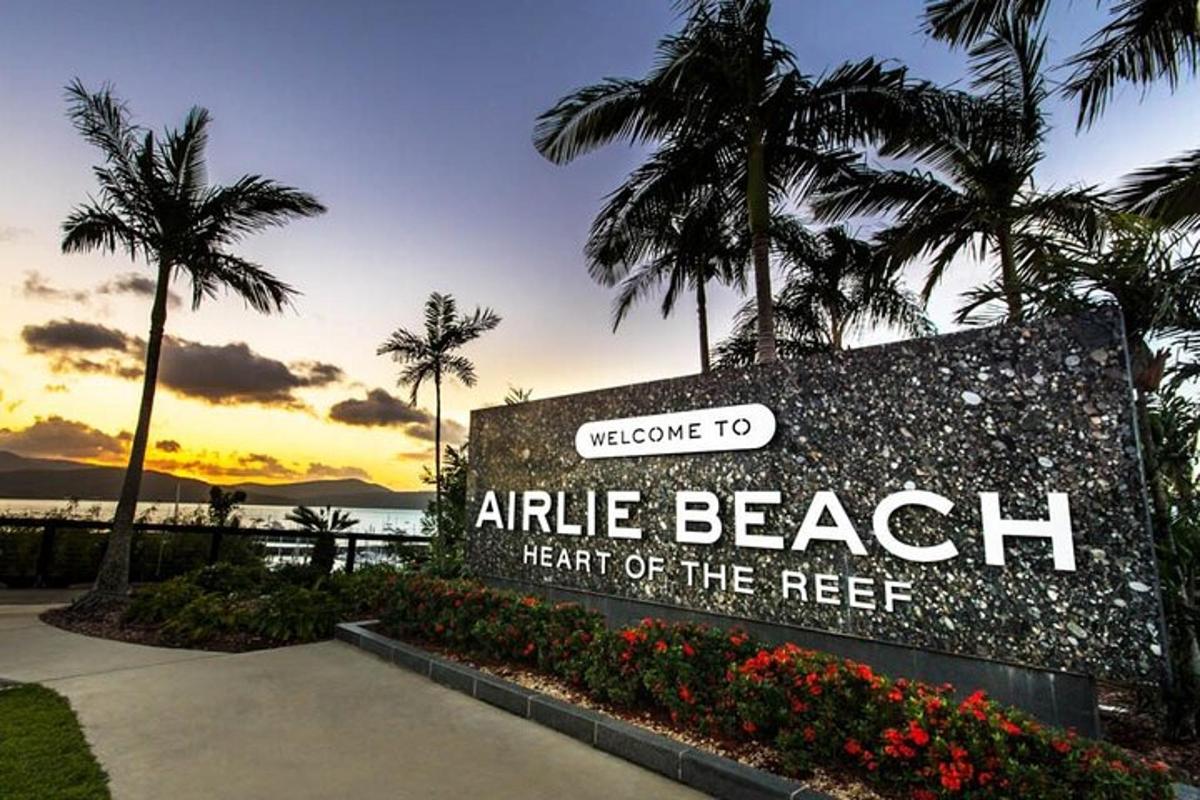 a sign at the entrance to the arlie beach heart of the reef