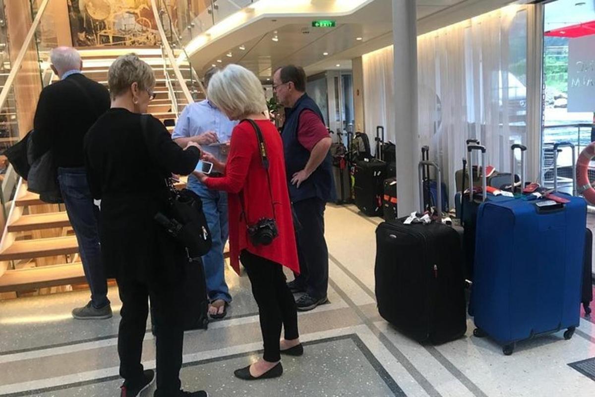 Un grupo de personas esperando su equipaje en un aeropuerto.