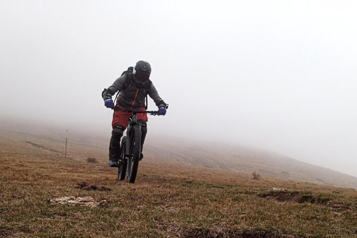 a man riding a bike on a hill in the fog