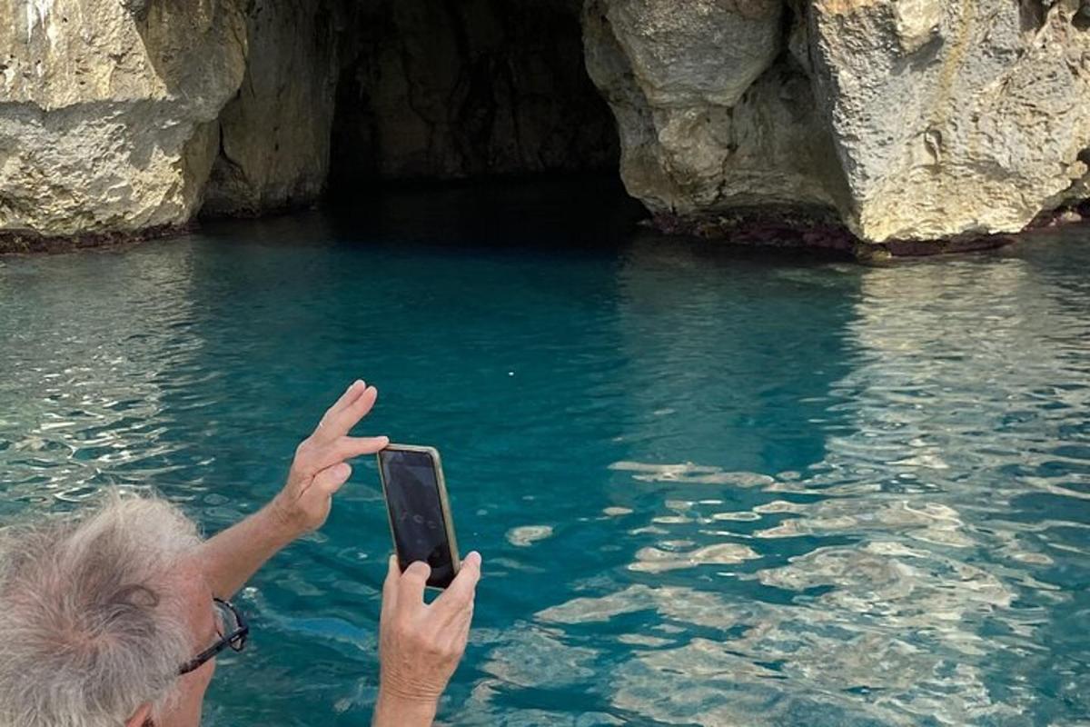 o persoană care fotografiază o peșteră cu telefonul mobil