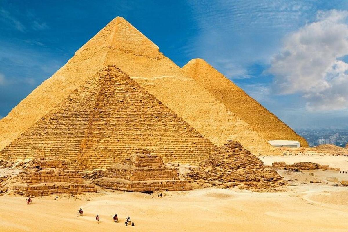مجموعة من الناس يقفون أمام الأهرامات