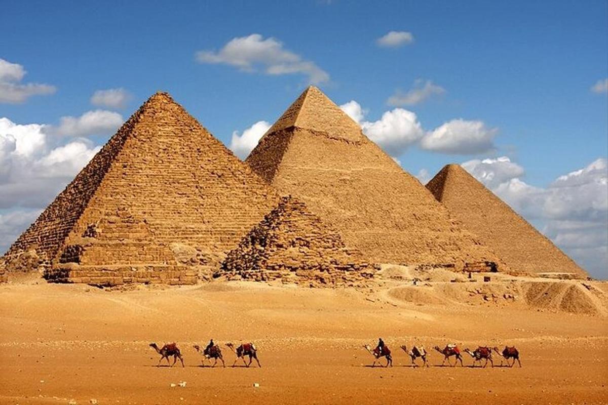 مجموعة من الناس يركبون الخيول أمام الأهرامات