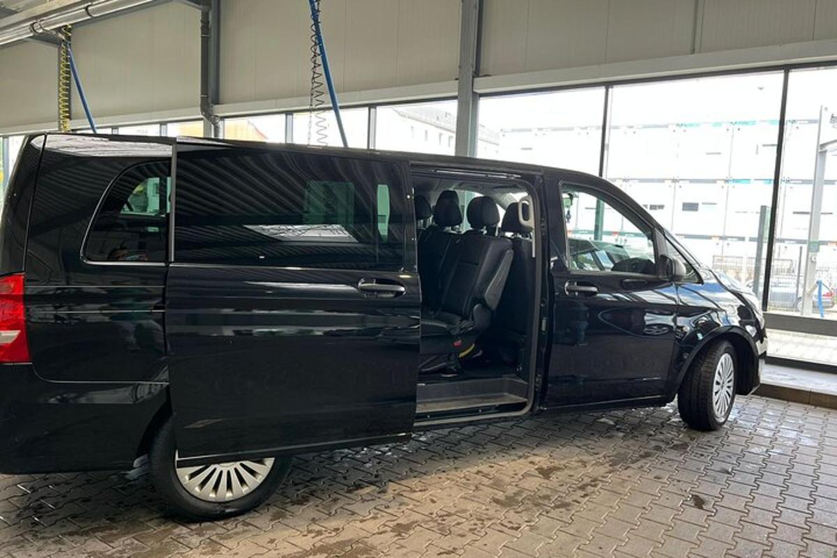 črn kombi parkiran v stavbi z odprtimi vrati
