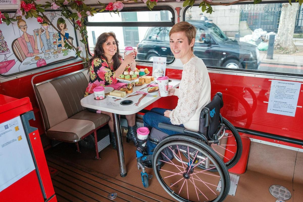 un uomo su sedia a rotelle seduto a un tavolo in un food truck