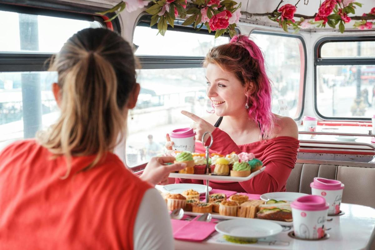 due donne sedute a un tavolo che mangiano cibo