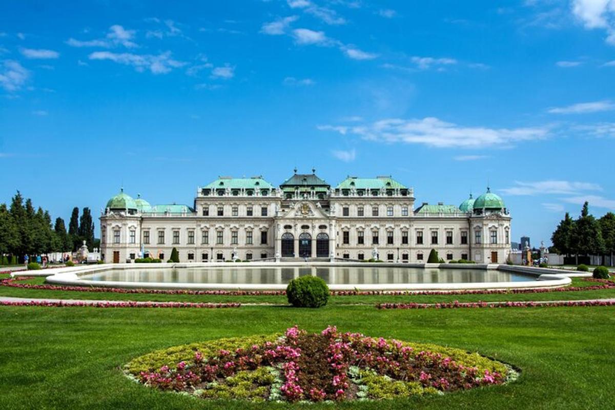 Un gran edificio blanco con un jardín delante.