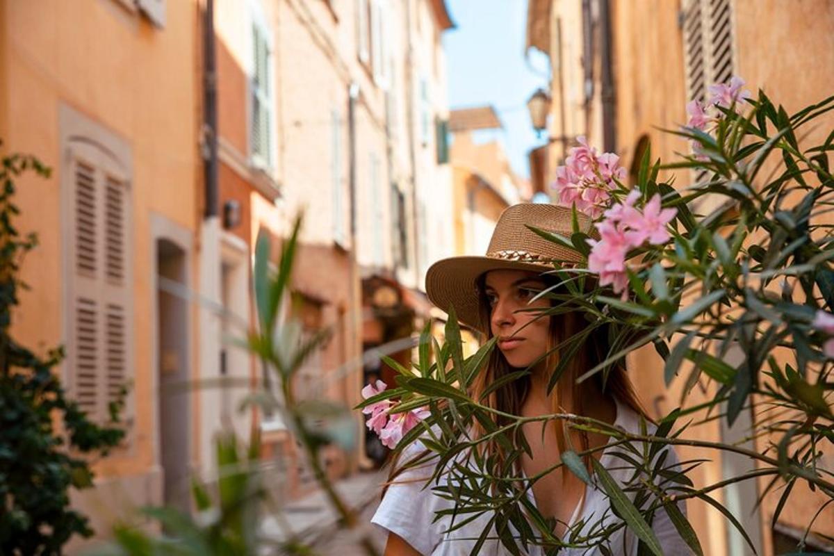 una donna che indossa un cappello in piedi accanto ad alcuni fiori