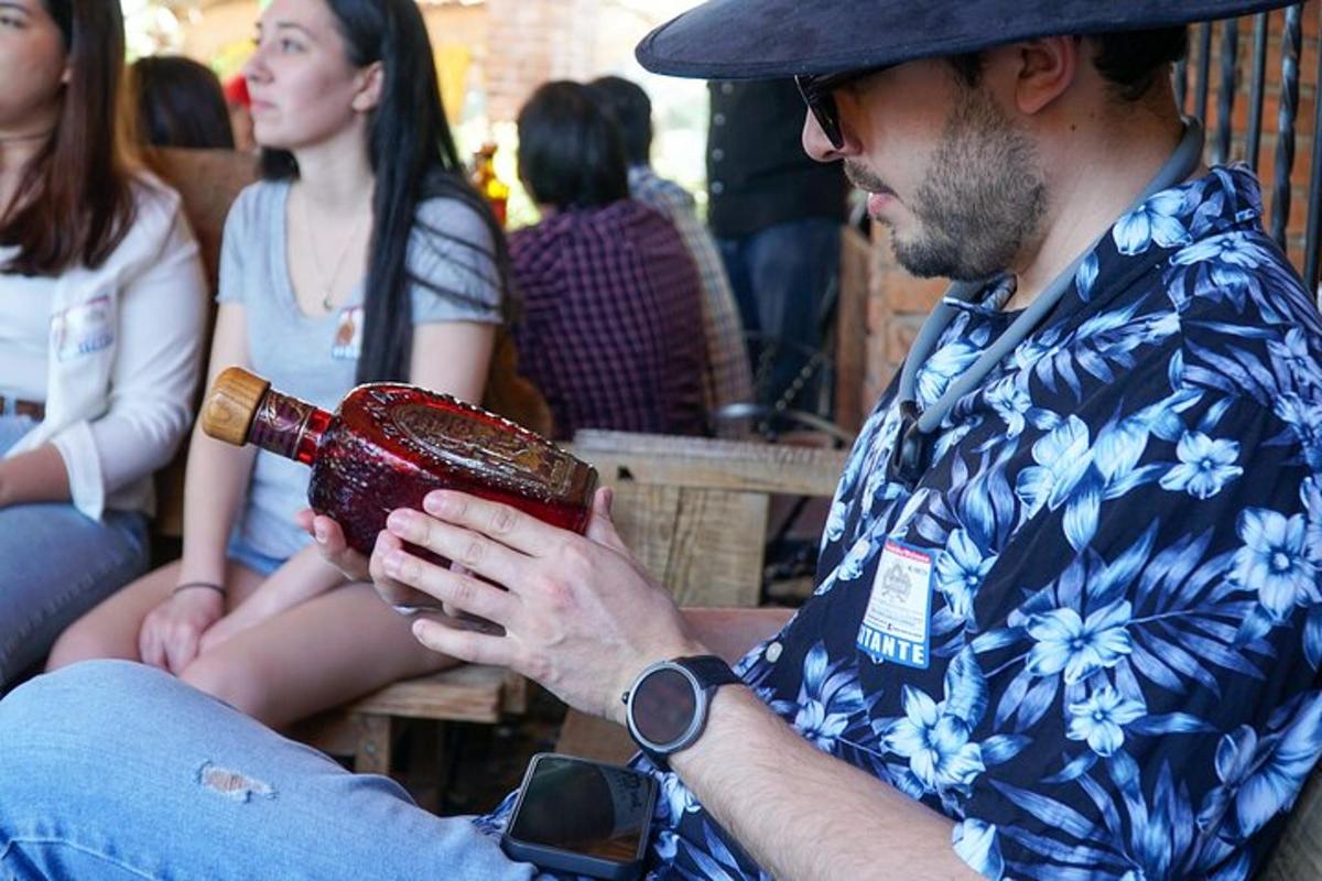 a man sitting on a bench holding a drink