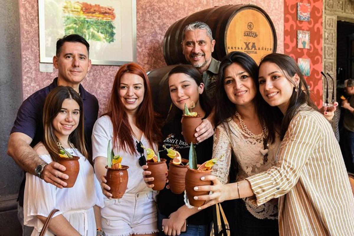 a group of people posing for a picture with a bottle of wine
