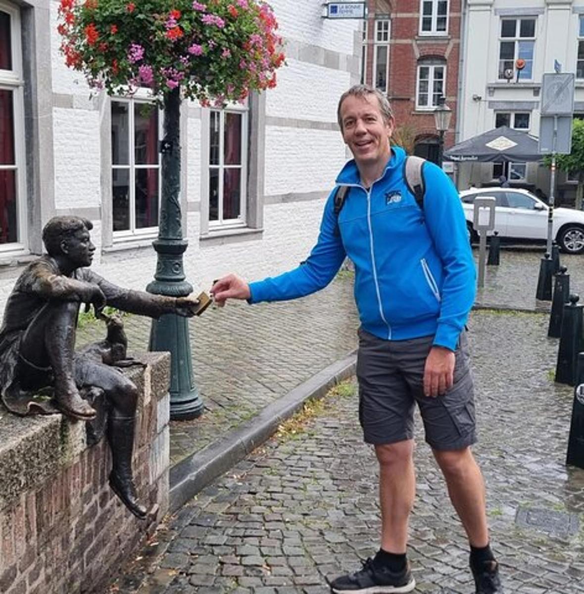 a man is standing next to a statue