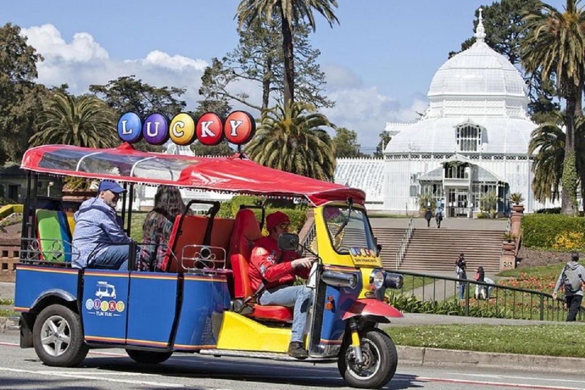 um carrinho de golfe circulando pela rua em frente a um prédio