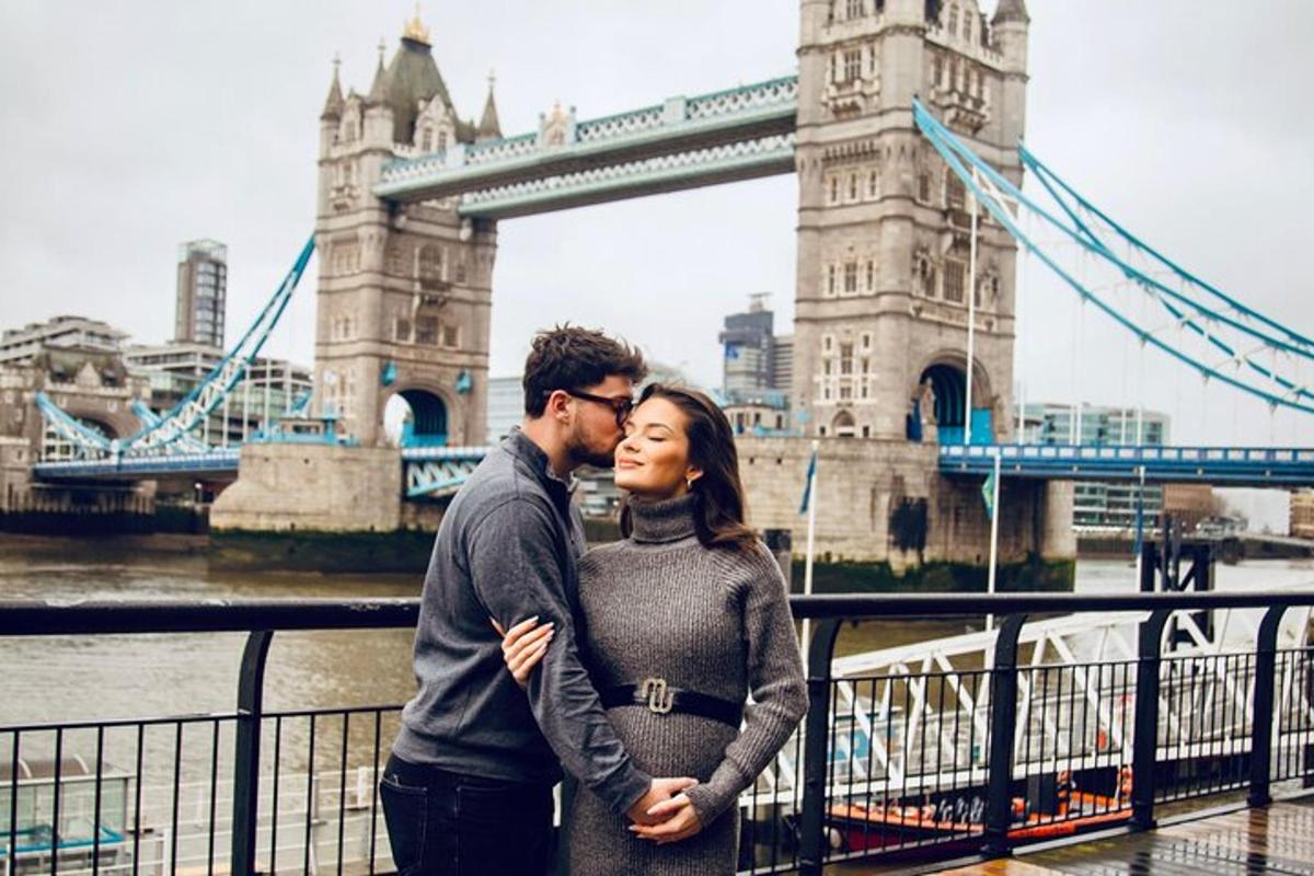 un uomo e una donna in piedi davanti al Tower Bridge