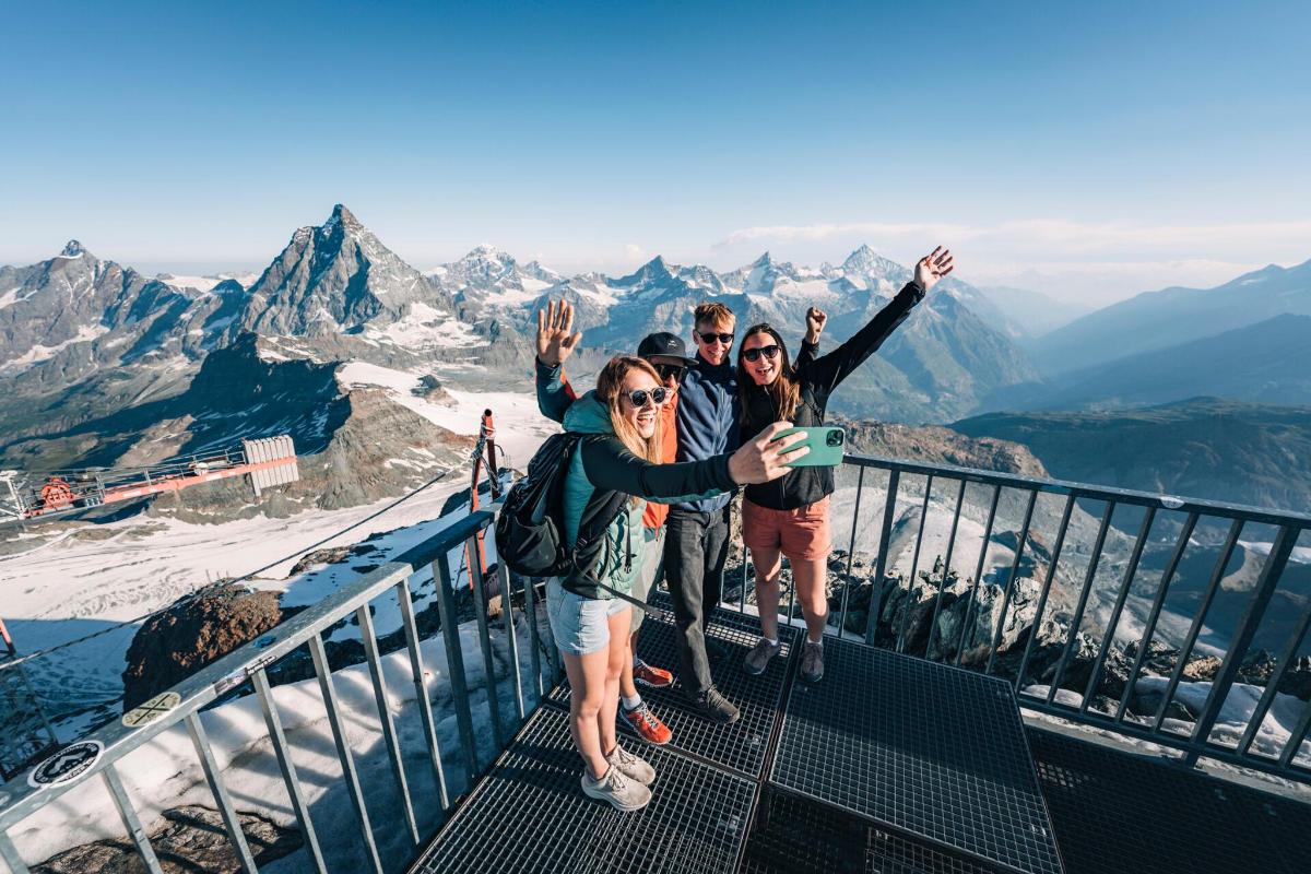 three people posing for a picture at the top of a mountain