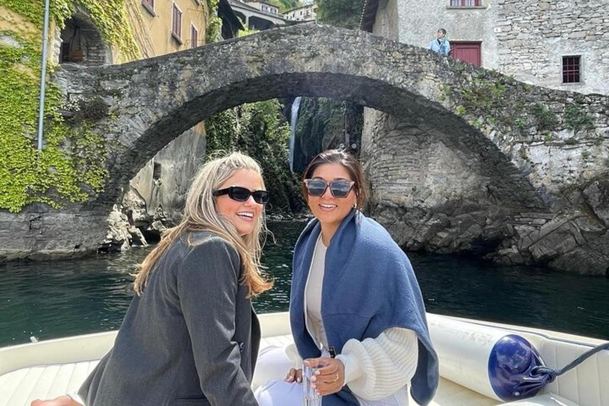 two women are standing on a boat in a river