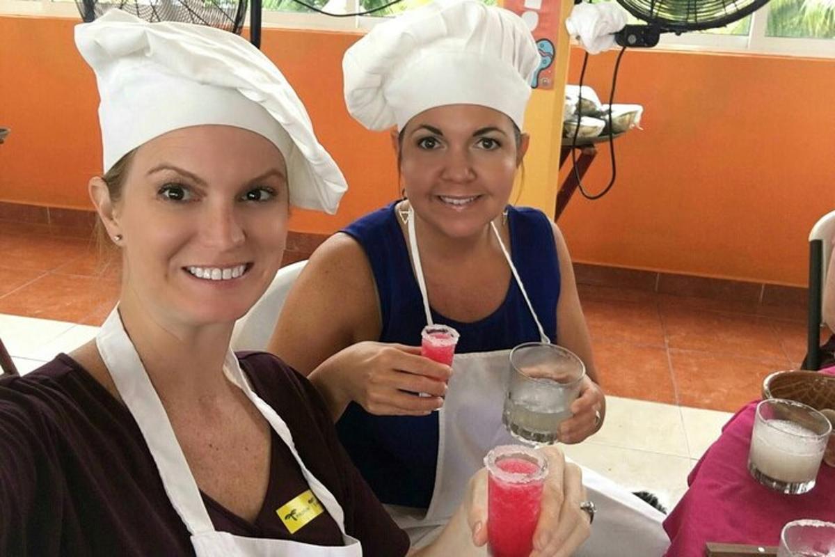 Dos mujeres con gorros de chef sentadas en una mesa con bebidas