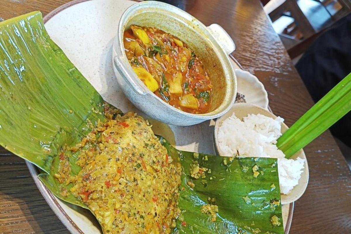 一盘食物、一碗汤和一片香蕉叶