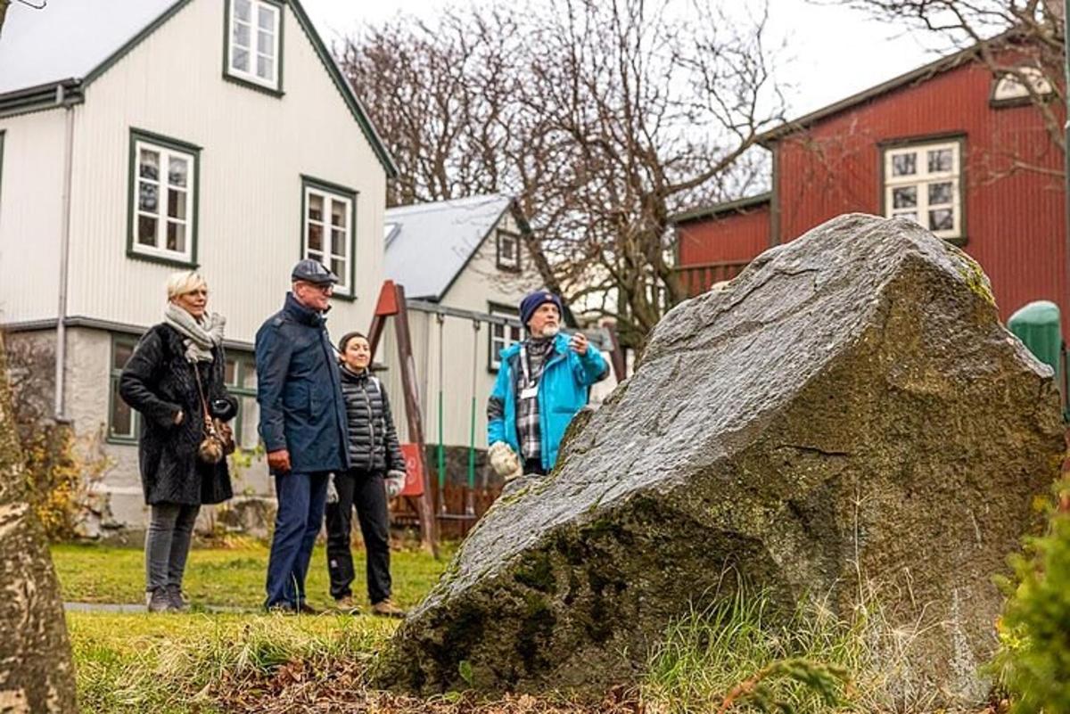 un gruppo di persone in piedi accanto a una grande roccia