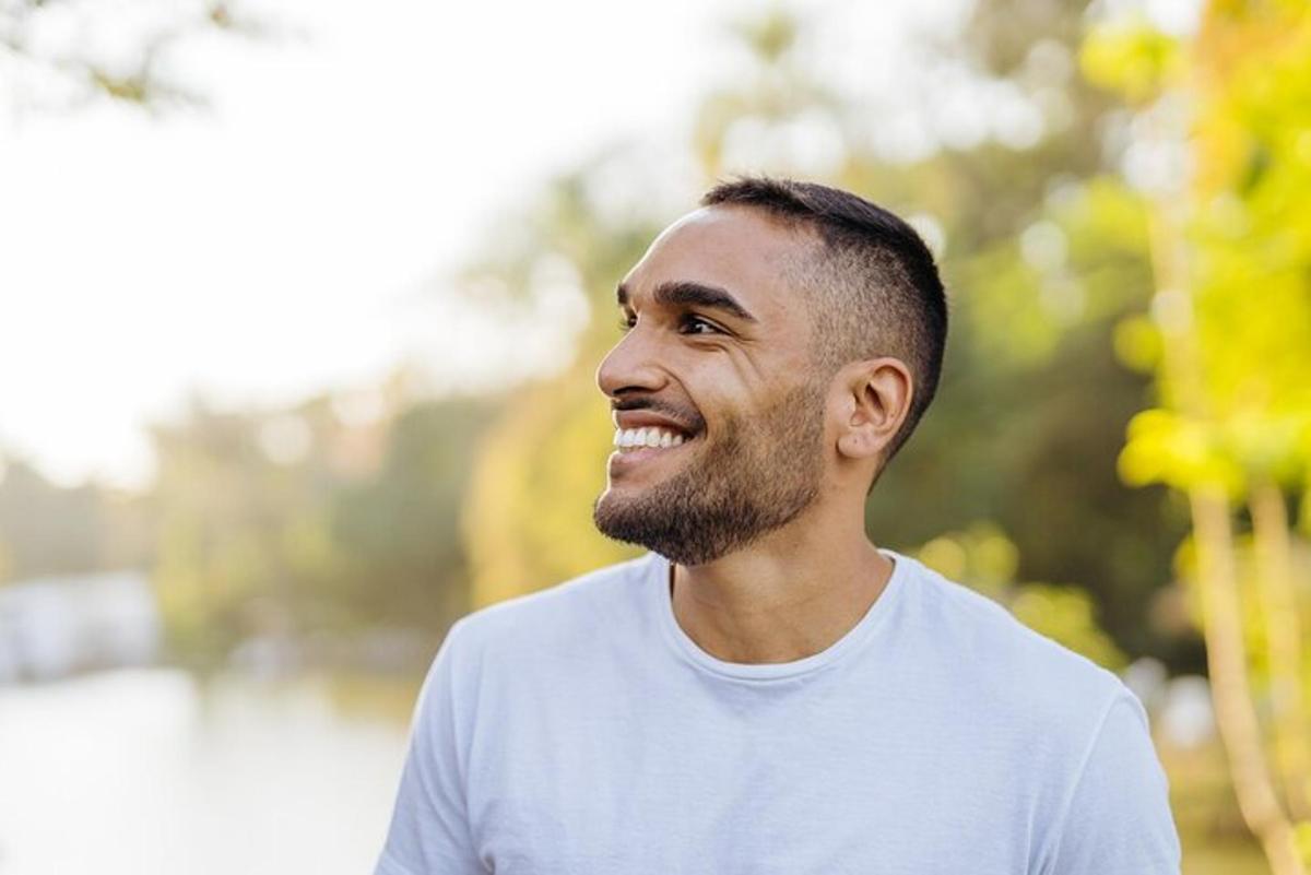 um homem de camisa branca está sorrindo