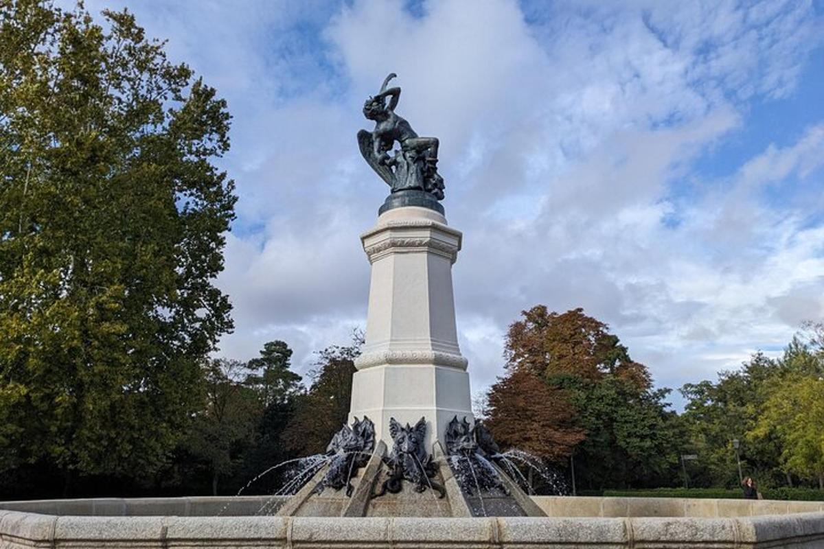 una estàtua d'una dona asseguda a sobre d'una font