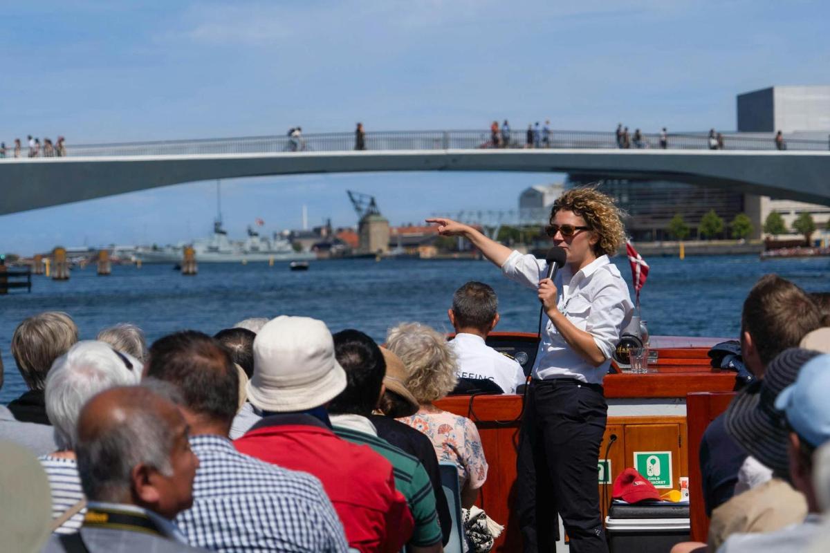 a woman speaking to a group of people on a boat