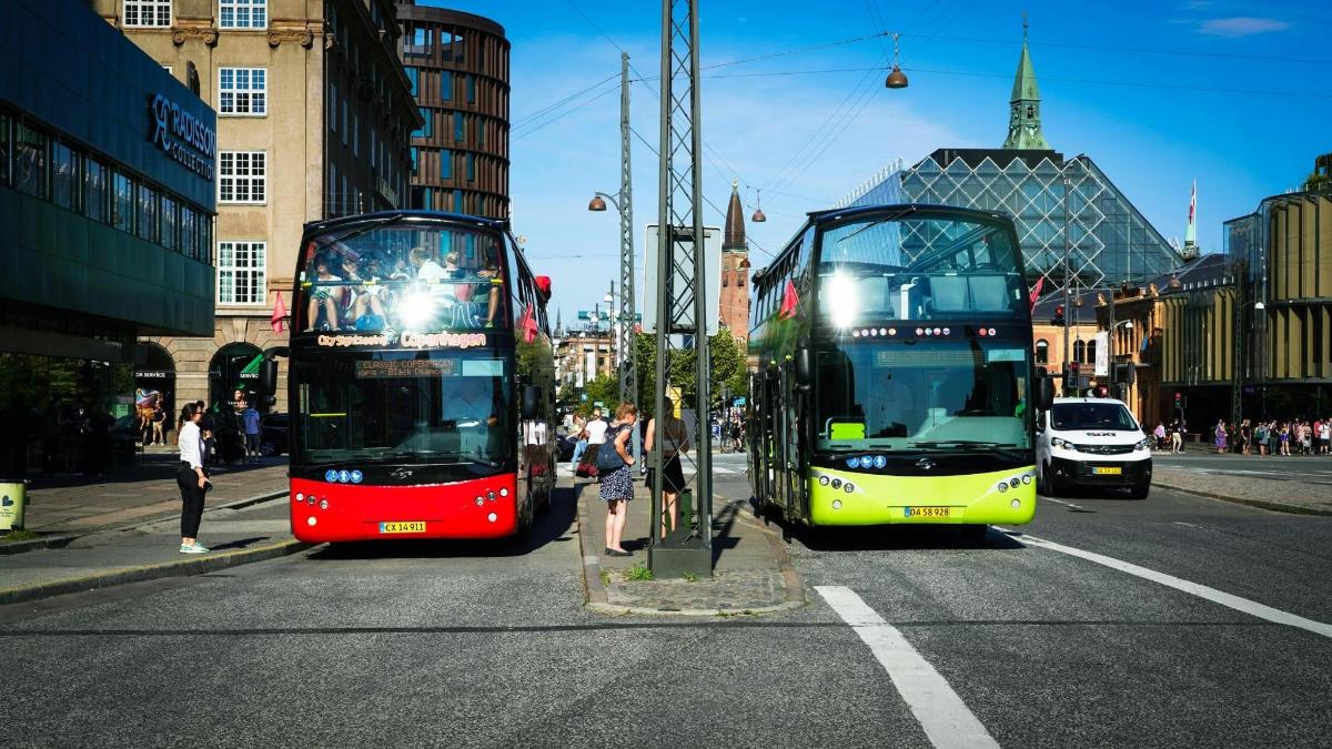 dva dvoupatrové autobusy jedoucí po městské ulici