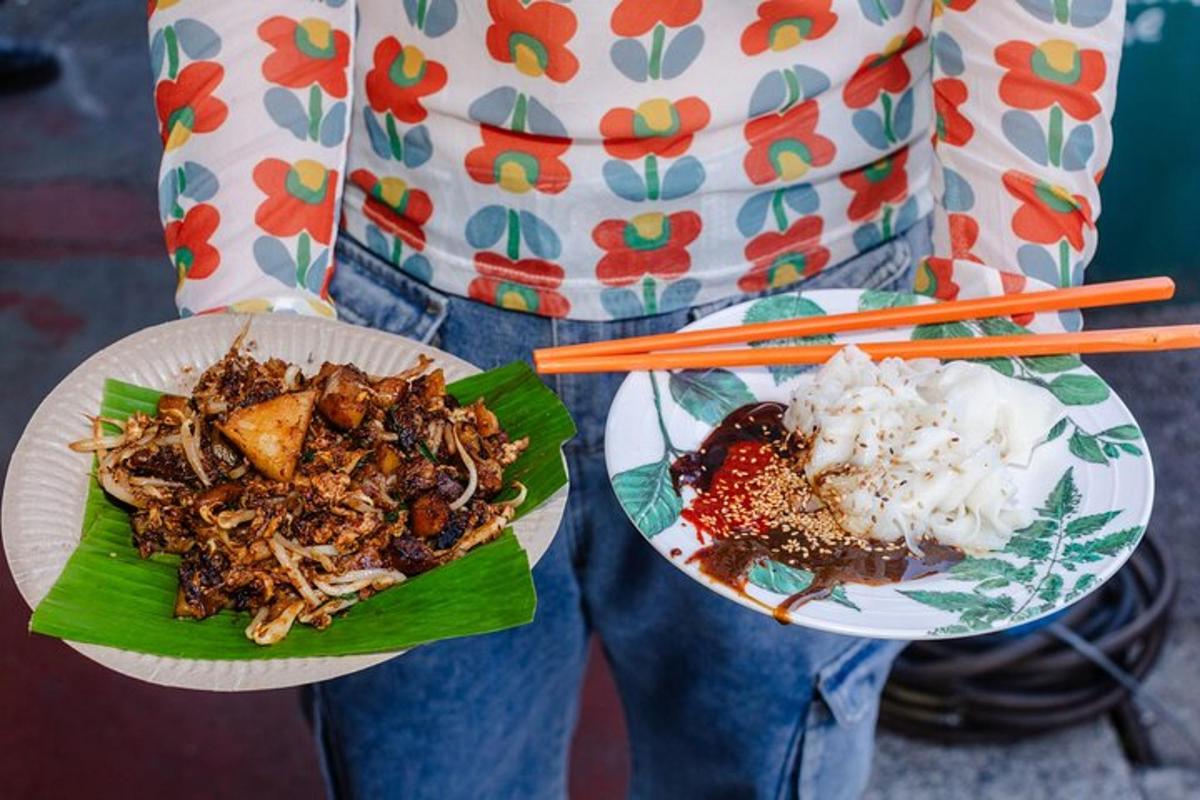 a person is holding two plates of food with chopsticks