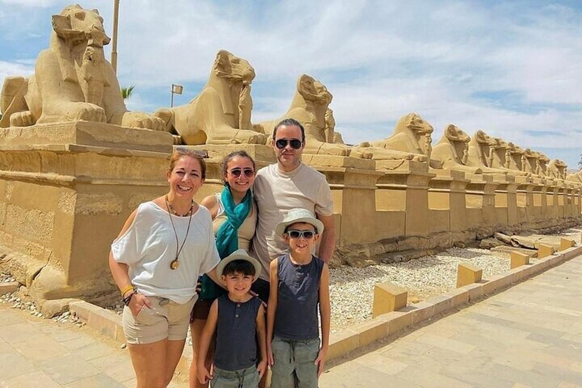 uma família posando em frente a uma escultura de areia