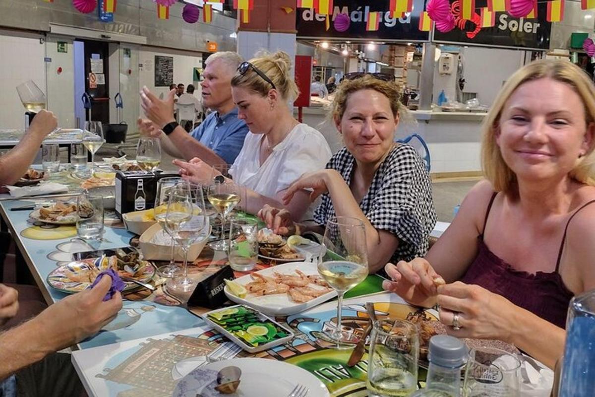 hópur fólks situr við borð og borðar mat
