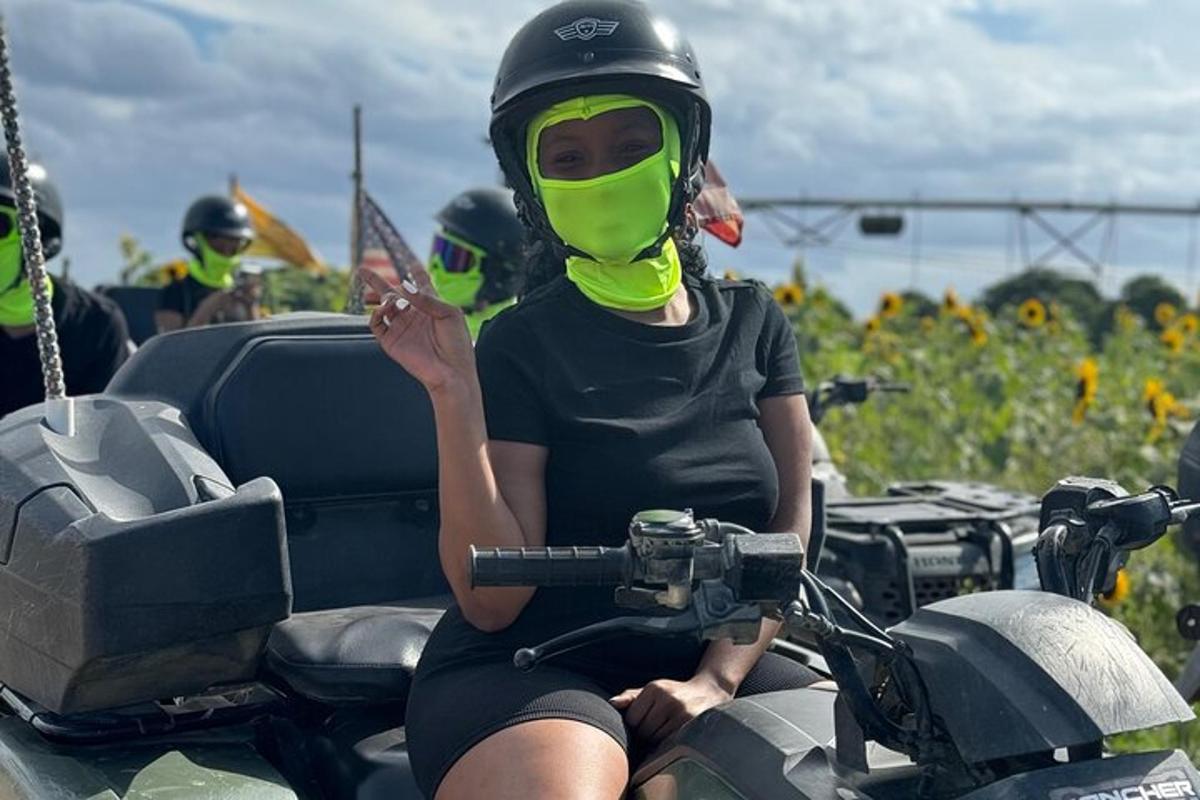uma mulher usando uma máscara facial verde em uma motocicleta